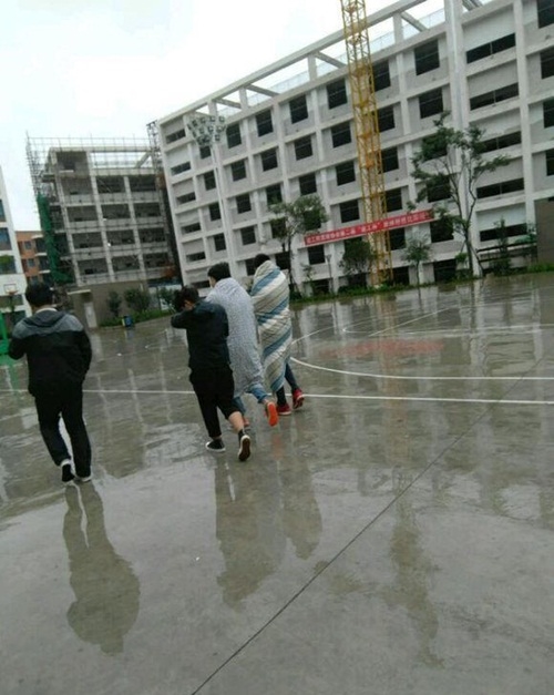 Hai nam sinh Trung Quốc chống lạnh bằng cách quấn chăn đến trường