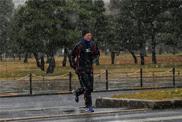 Người dân rét buốt chạy bộ trong sớm tuyết rơi. (Ảnh: Reuters).