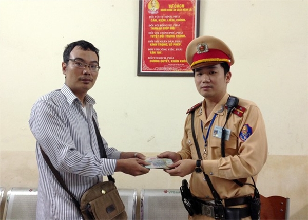 Thượng úy Nguyễn Đức Thắng trả lại giấy tờ và tiền bị đánh rơi cho chủ nhân của nó. (Ảnh: Internet)