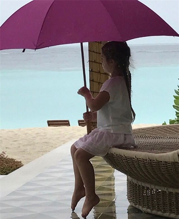 Ngồi cầm ô suy tư trong mưa.