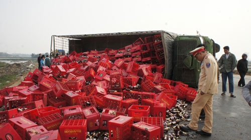 
	
	Hàng trăm thùng bia chai đã tràn xuống mặt đường khi xe tải lật ngang.