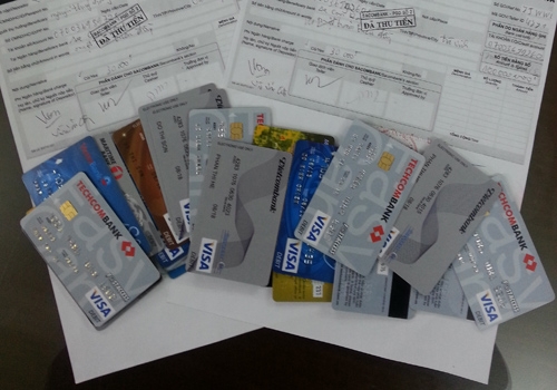 
	
	Giấy biên nhận nạn nhân nộp tiền và những chiếc thẻ được chúng rút tiền của các bị hại.