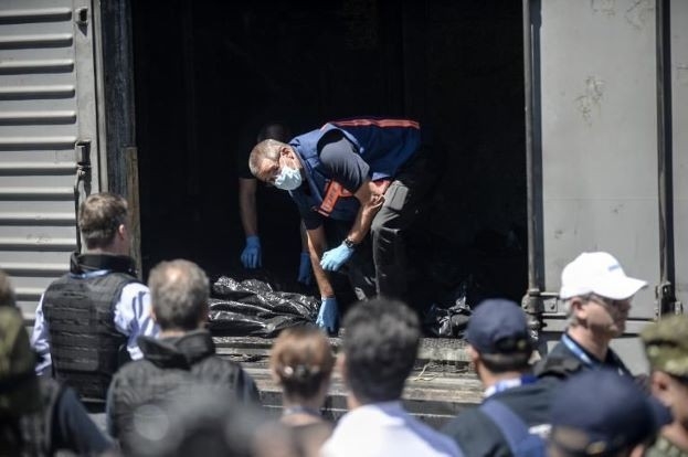 
	
	Các quan sát viên từ Tổ chức An ninh và Hợp tác châu Âu kiểm tra túi đựng thi thể nạn nhân trước khi tàu hỏa rời trạm ở Torez. Ảnh: MSN