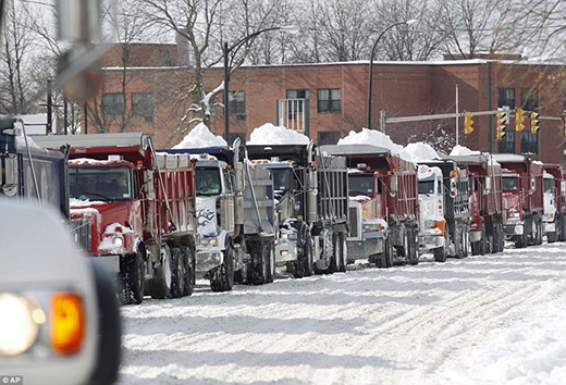 
	
	Hàng dài xe tải xếp hàng chờ đợi đến lượt đổ tuyết tại bãi ở Buffalo, New York.