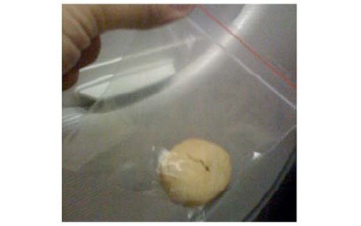 
	
	Chiếc bánh được gói trong túi và mô tả như là một 'tang vật' của vụ án.