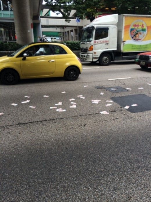 
	
	Những tờ tiền rải khắp đường. Ảnh: SCMP