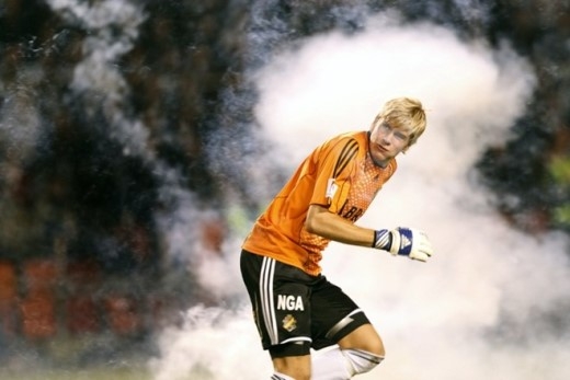 
	
	Thủ môn Toni Maanoja của AIK né tránh những quả pháo sáng do CĐV ném ra từ khán đài trong trận gặp Hammarby tháng 8/2008.