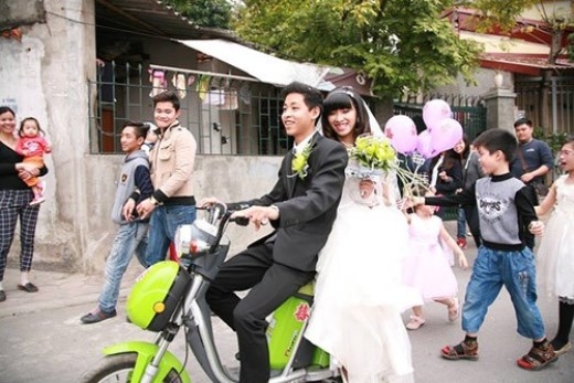 
	
	Chú rể Nguyễn Thanh Tùng chở cô dâu bằng xe đạp điện ở Hà Nội.