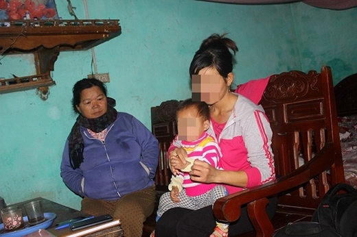 
		
		Chị Hà bế đứa con gái thứ 2 và mẹ chồng trong ngôi nhà.