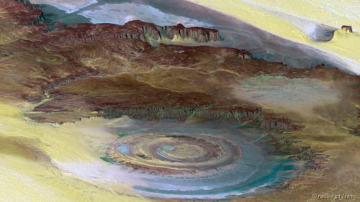 
	
	Con mắt Sahara, còn được gọi là cấu trúc Richat, hình thành trên sa mạc Sahara. Đây là một khối đá có hình vòm rộng khoảng 50 km. Nhiều người từng cho rằng nó xuất hiện sau tác động của một vụ va chạm thiên thạch. Ngày nay, nó được cho là hình thành từ những tảng đá trồi lên mặt đất nhưng sau đó xói mòn. Ảnh: NASA