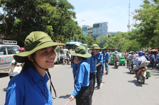 
	
	Sinh viên tình nguyện đứng giữa trời nắng hơn 40 độ c để phân luồng giao thông ở Hà Nội. Ảnh: DT