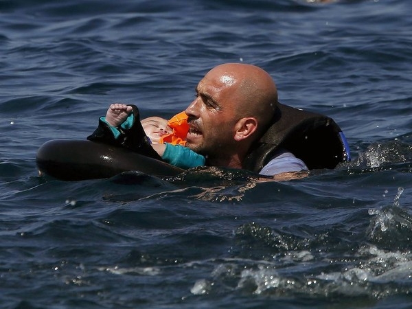 
Bức ảnh kể về câu chuyện của một người đàn ông Syria đã đặt con lên xuồng cao su chở người tị nạn, chiếc phao đã bị xì hơi khi mà nó sắp cập bờ biển Hi Lạp 100m. Và hình ảnh này tượng trưng cho những nguy hiểm mà những người tị nạn phải đối mặt. (Ảnh Internet)