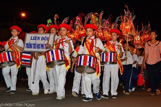 
Đêm hội trăng rằm bắt đầu, các em học sinh di chuyển theo hàng diễu hành trên các trục đường chính của Phan Thiết. 