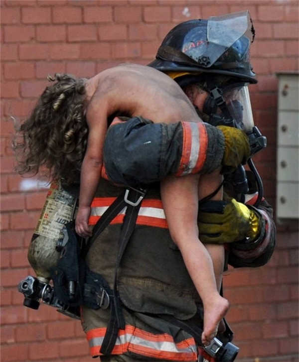 
Người lính cứu hỏa đang cứu cô gái nhỏ người Mỹ