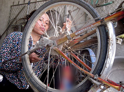 
Nghề sửa xe đạp giúp chị nuôi con khôn lớn. Ảnh: Đức Hùng