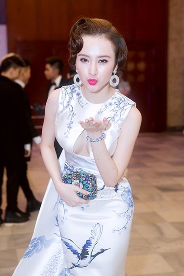 
Angela Phương Trinh cũng từng gây ấn tượng mạnh khi diện bộ váy có họa tiết rồng phượng, chim hạc tông xanh lam theo phong cách cổ điển với mái tóc xoăn nhẹ.