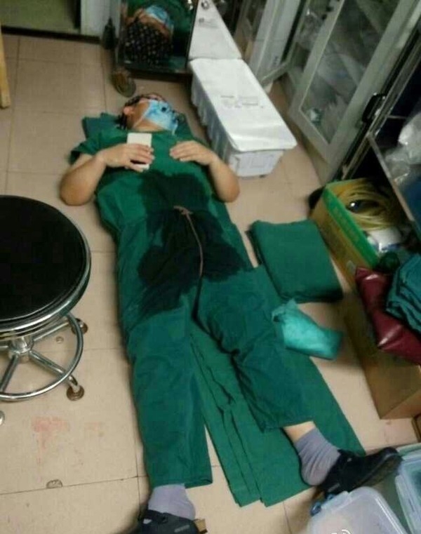 
Bức ảnh chụp lại khoảnh khắc anh đang mặc bộ đồ phẫu thuật ngủ thiếp ngay tại phòng mổ. (Ảnh Internet)