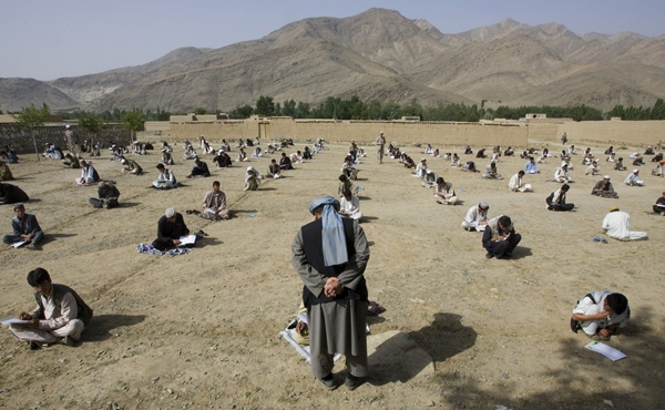 
Tháng 7/2009, hình thức thi ngoài trời đã được áp dụng tại một ngôi trường ở làng Sangarkhel (Afghanistan). Học sinh ngồi thẳng hàng trên nền đất để làm bài thi cuối kì. (Ảnh Internet)