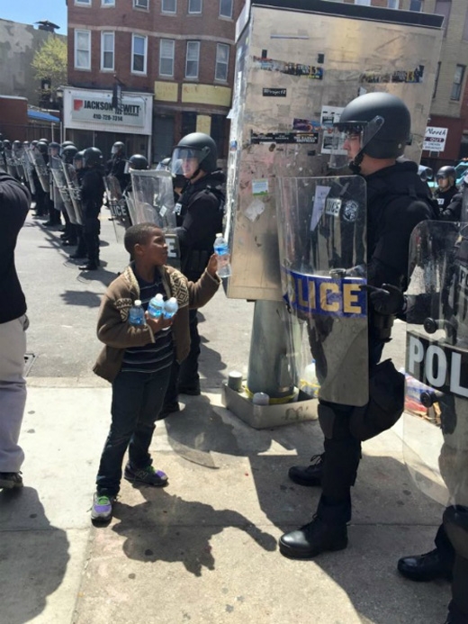 
Cậu bé này đem nước cho cảnh sát trong một ngày nắng nóng. (Ảnh: Internet)