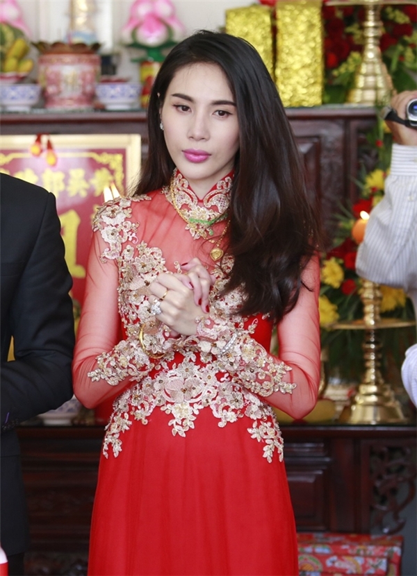 
Bộ áo dài đỏ của Thủy Tiên trở nên nổi bật hơn nhờ những chi tiết ren đính kết màu vàng kim. Đám cưới của nữ ca sĩ gần như là sự kiện hot nhất làng giải trí Việt Nam trong năm 2015.
