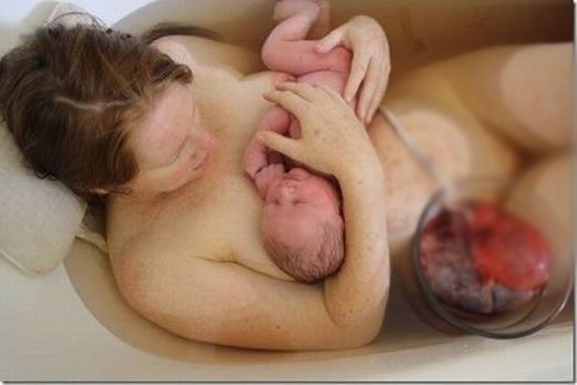 
Em bé được mẹ ôm trong vòng tay, bên cạnh là dây rốn và nhau thai đang còn dính với nhau. (Ảnh: Oddee)