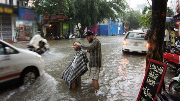 
Một lần cắt tóc tại Việt Nam khác: giữa đường phố ngập nước. (Ảnh: Internet)