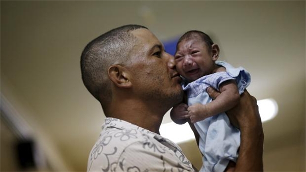 
Một người bố ôm đứa con bị bệnh đầu nhỏ tại Bệnh viện Oswaldo Cruz (Brazil). Ảnh: Internet