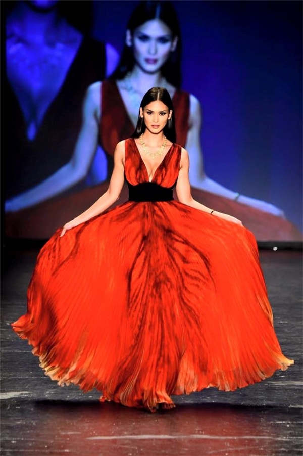 
Trên sàn diễn, Pia diện chiếc váy đỏ xẻ ngực sâu hút gợi cảm. Thiết kế được thực hiện trên nền chất liệu voan lụa mềm mại với những đường dập li tinh tế. Từng bước di chuyển của Pia giúp chiếc váy trở nên mềm mại, thanh thoát hơn. Đây là thiết kế của nhà mốt Carmen Marc Valvo.