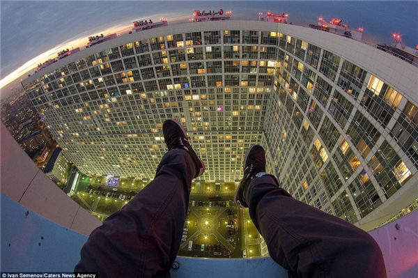 
Bức ảnh chụp đôi chân của một kẻ liều lĩnh ngồi mấp mé trên bờ tường của tòa nhà cao tầng ở Moscow và trông ra đường chân trời. (Ảnh: Daily Mail)