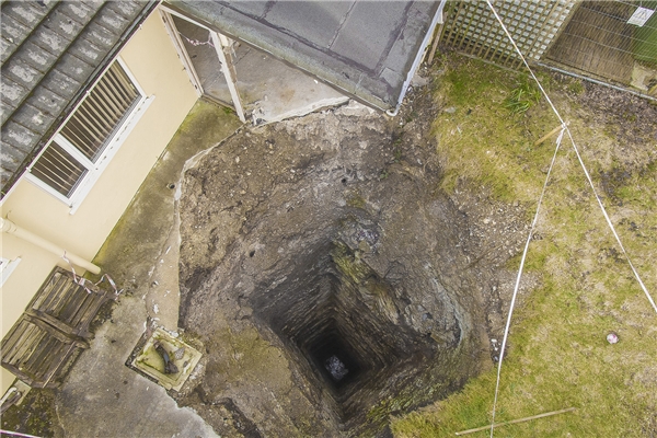 
 Hố sâu hơn 90m đột nhiên xuất hiện sau vườn nhà của một hộ dân ở Cornwall. (Ảnh: The Sun)