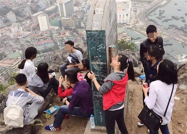 
Nhóm bạn trẻ này viết bậy lên bia đá di tích lịch sử trên Núi Bài Thơ.  Ảnh: Trần Văn Long.