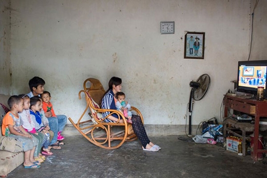 
Bế đứa con gái một tuổi trong lòng, Xin, 16 tuổi, đang ngồi xem hoạt hình cùng chồng và những đứa trẻ hàng xóm. Đôi vợ chồng trẻ bắt đầu hẹn hò 3 năm trước, khi đang học lớp 5.