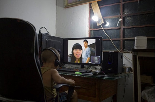 
Cậu bé Le, 3 tuổi, đeo tai nghe và ngồi trước màn hình máy tính để trò chuyện với mẹ. Người mẹ 20 tuổi đang làm công nhân ở tỉnh Chiết Giang và gửi con nhờ gia đình chú ở quê chăm sóc. Tại các vùng nông thôn, không ít trường hợp nghỉ học giữa chừng, kết hôn và tìm kiệc ở nơi khác, để lại con cho ông bà chăm sóc. 