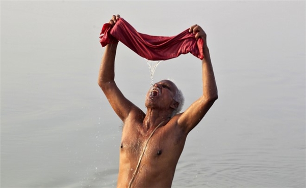 
Một người đàn ông vắt tấm vải và uống nước ở sông Hằng tại thành phố Allahabad ngày 18/4. Nhiệt độ ở nơi này hôm đầu tuần ghi nhận đạt 43 độ C. Cơ quan khí tượng Ấn Độ cho biết, các mốc nhiệt độ đo được vào thời điểm này đã cao hơn từ 8 đến 10 độ so với những tháng 4 các năm trước.