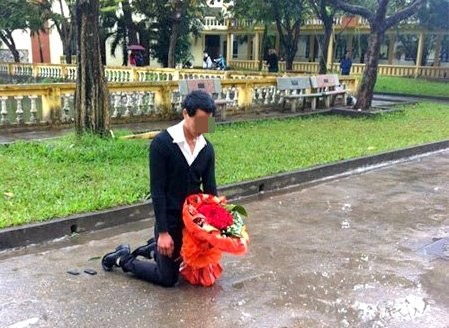 
Hay tại sân trường ĐH Sân khấu Điện ảnh Hà Nội, từng có một chàng trai đứng dưới mưa cùng bó hoa trên tay để xin lỗi bạn gái. Sau nhiều giờ chờ đợi, chàng trai quỳ gục xuống. Trước cảnh tượng khổ sở của nam thanh niên, nhiều sinh viên trong trường đã đến che ô, khuyên nhủ anh ra về. Ảnh: Internet