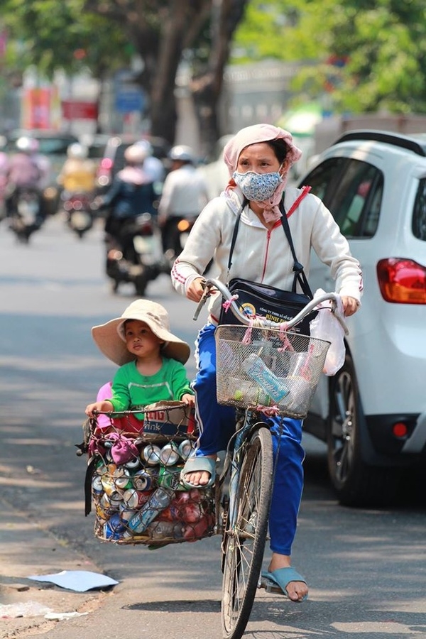 
Hình ảnh một người mẹ bán ve chai đưa con đi khắp mọi nẻo đường. (Ảnh: Nguyễn Vĩnh Sơn).