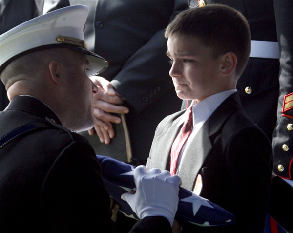 
Cậu bé 8 tuổi Christian Golczynski cố gắng kìm nén nước mắt trong buổi tiễn đưa linh cữu của bố mình, một sĩ quan hy sinh trong khi đang làm nhiệm vụ.