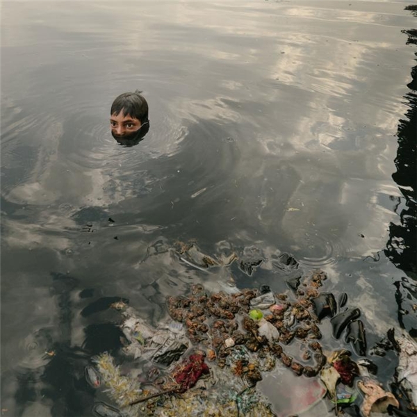 
Cậu bé này đang ngụp lặn dưới làn nước đen ngòm của sông Yamuna để mò những món đồ kim loại mà người ta vứt từ trên cầu xuống, chẳng hạn đồng xu hay những bức tượng Phật nhỏ.