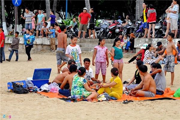 
Một số đại gia đình thuê bạt trải ngồi thay nhau trông đồ và ăn uống luôn trên cát.