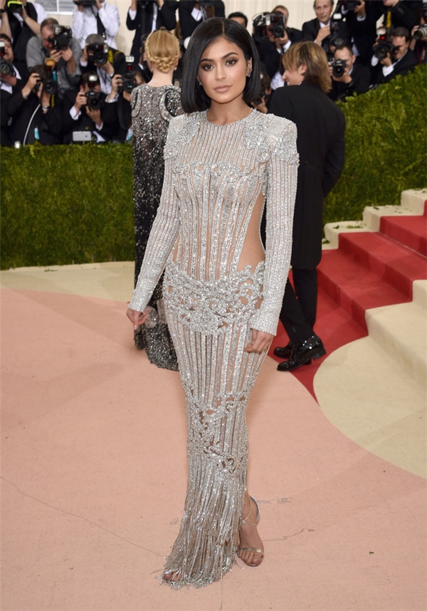 
Kylie Jenner khoe dáng đồng hồ cát trong chiếc váy xuyên thấu kết hợp chi tiết ánh kim của Balmain.