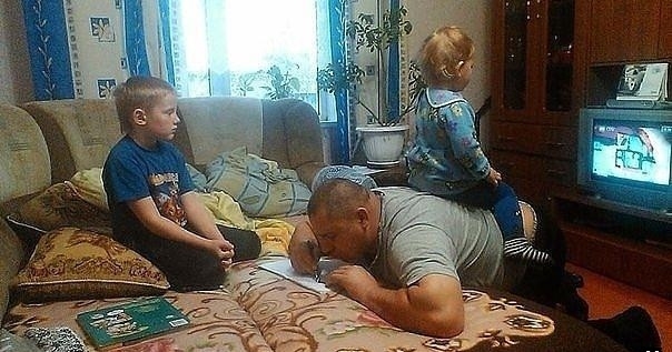 
Ông bố của năm: Làm bài tập cho con trai trong khi làm ghế đệm cho con gái. (Ảnh: Internet)