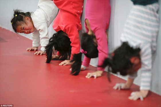 
Một số bé gái tập trồng cây chuối tại một ngôi trường thể thao ở Thượng Hải, có em vì đã hết sức nhưng cũng chỉ biết vừa khóc vừa tập.