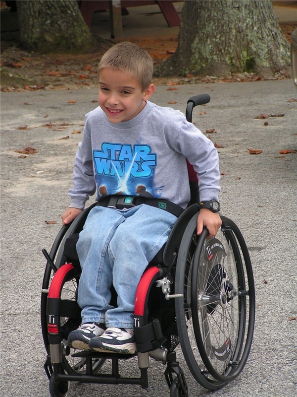 
Samuel phải đeo nẹp chân và đi xe lăn suốt đời, dù vậy cậu bé rất lạc quan vào cuộc sống.