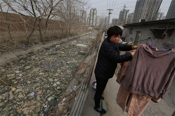 
Người dân sống trên bờ sông ngập ngụa rác ở Bắc Kinh, Trung Quốc.