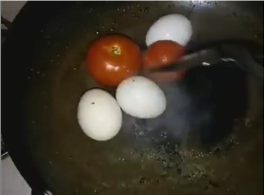 
Cô gái xào cà chua với trứng "nguyên con"... (Ảnh: Cắt clip)