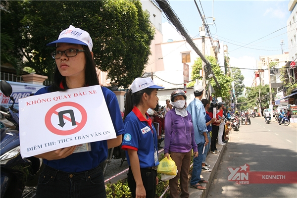 
Nữ tình nguyện viên này đang hướng dẫn giao thông tại điểm thi trường THCS Trần Văn Ơn.