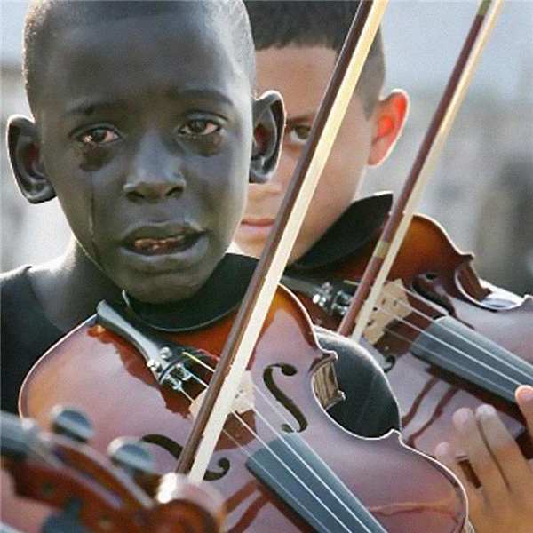 
Bức ảnh chụp lại cảnh một cậu bé 12 tuổi người Brazil chơi đàn violon tại lễ tang của thầy mình. Ngày còn sống, thầy cứ như một người bạn quyền lực và thấu hiểu lòng người, ông đã giúp đỡ rất nhiều trẻ em khốn khó thoát cảnh đói nghèo, bạo lực nhờ vào âm nhạc. (Ảnh Internet)