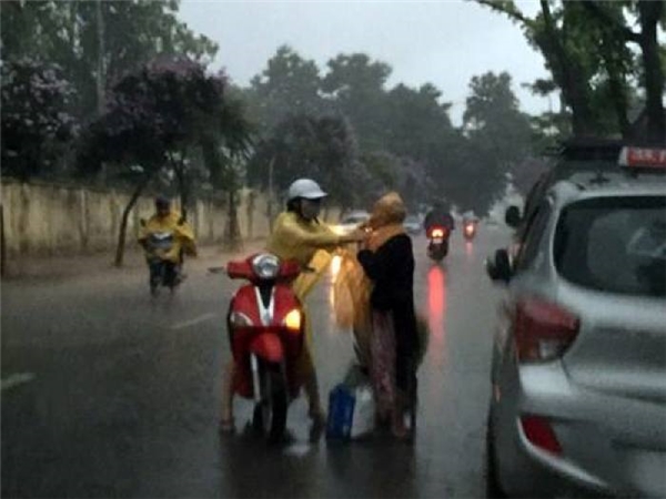 
Cách đây không lâu, trong một ngày Hà Nội mưa tầm tã, hình ảnh cô gái đi xe máy dừng lại giữa đường, cởi áo mưa và mặc cho một bà cụ xa lạ đã khiến dân mạng vô cùng cảm phục. (Ảnh: Internet)
