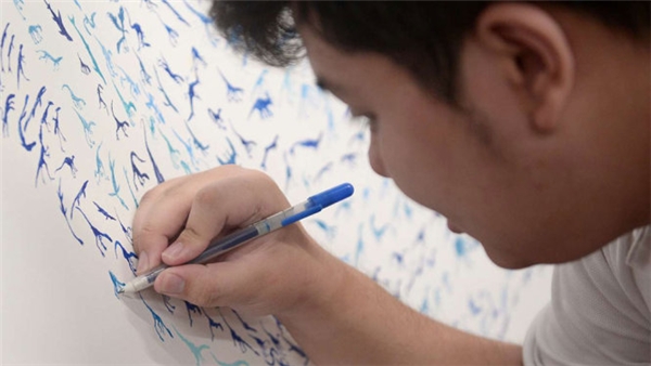 
Chàng trai tự kỉ See Toh Sheng Jie vẽ hình khủng long. (Ảnh: STRAITS TIMES)