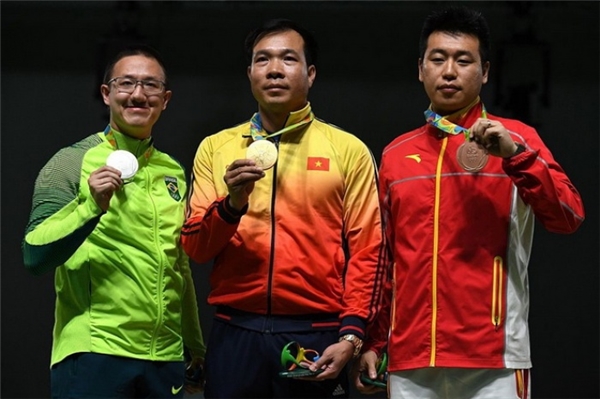 
Hoàng Xuân Vinh, VĐV giành HCB của nước chủ nhà Brazil, Felipe Almeida Wu (trái) và VĐV của Trung Quốc Pang Wei (phải) giành HCĐ trên bục nhận giải. 